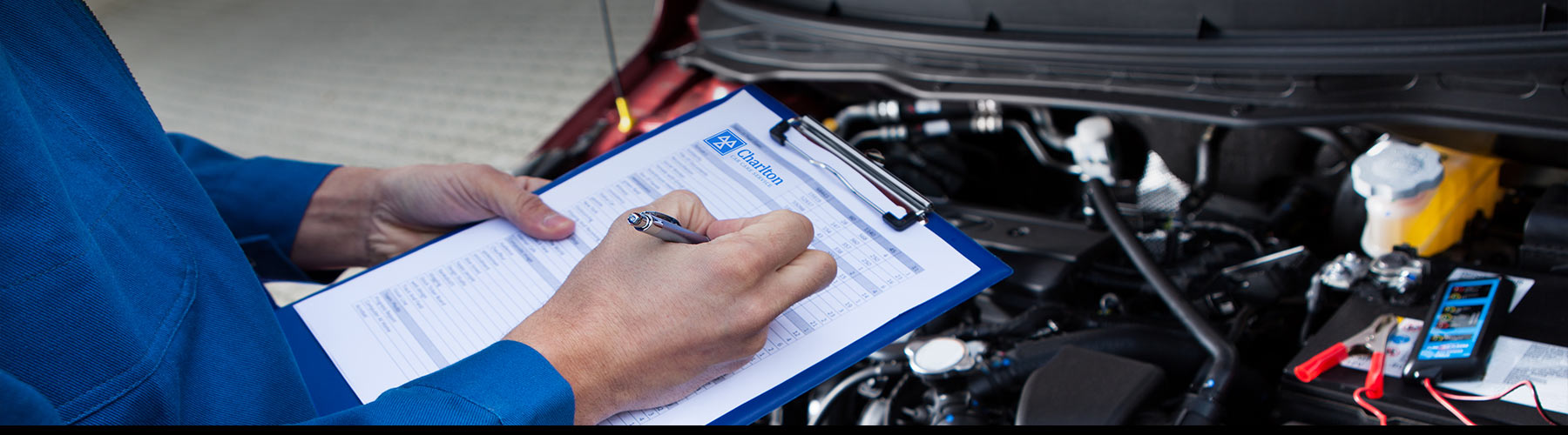 Man with clipboard checking off items to pass MOT Test